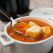 A Bon Chef stainless steel soup spoon in a bowl of soup.