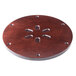 A circular wooden surface with metal holes.