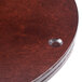 A close up of a cherry wood table with a hole in it.