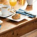 A Villeroy & Boch white rectangular porcelain plate with food and a drink on a table.