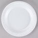 A white Dart foam plate on a gray surface.