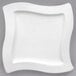 A close-up of a Villeroy & Boch NewWave white porcelain plate with a wavy edge.