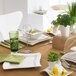 A table set with Villeroy & Boch white porcelain plates and green napkins.