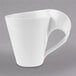 A close-up of a Villeroy & Boch white porcelain mug with a curved handle.