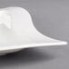 A close up of a white Villeroy & Boch square porcelain plate with a curved edge.
