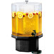 A Cal-Mil Classic beverage dispenser with yellow liquid and lemons in the ice chamber.