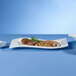 A Villeroy & Boch white porcelain platter with meat and sausages on it.