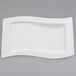 A white Villeroy & Boch porcelain platter with a curved edge on a gray surface.