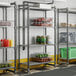 A metal shelving unit with four vented shelves, used for storage in commercial kitchens or pantries.