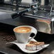 A Villeroy & Boch white porcelain coffee cup with coffee and cake on a plate.