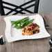 A Villeroy & Boch square porcelain plate with fish and green beans on it.