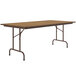 A rectangular Correll medium oak folding table with metal legs.