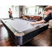 A man playing pool on a Mizerak pool table in a living room.