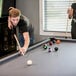 A man and woman playing pool on a Mizerak Dakota pool table.