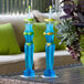 Two blue and yellow bikini yarders filled with blue and green drinks on a table.