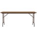 A Correll rectangular medium oak folding table with metal legs.