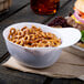 A white mini baseball helmet bowl filled with pretzels.