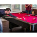 A man and a woman playing pool on a Mizerak Donovan II pool table.