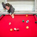 A man playing pool with a cue stick.