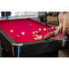 A woman playing pool on a red Mizerak Donovan II pool table.