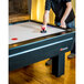 A man playing air hockey on an Atomic air hockey table.