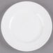 A Libbey Alpine White Porcelain Plate with a rim on a gray surface.