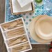 Bambu disposable bamboo knives on a table with plates and cutlery.