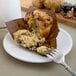 A Libbey Alpine White Porcelain coupe plate with a muffin and fork.