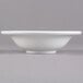 A close up of a Libbey Alpine White Porcelain grapefruit bowl on a gray surface.