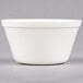 A white Carlisle polycarbonate bouillon cup on a grey surface.