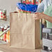 A woman holding a brown Duro Mart shopping bag.