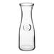 An Acopa clear glass carafe with a round neck and a lid.