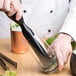 A person using a black stick to make a drink.