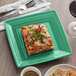 A piece of lasagna on a Tuxton Concentrix cilantro green square plate.