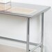 An Advance Tabco stainless steel work table with an open base.