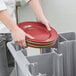 A person using a Cambro Versa dish caddy to hold a stack of plates.