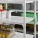 A white Cambro Camshelving® Premium shelf kit with fruit on it.