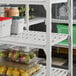 A Cambro Camshelving® Premium unit with 4 vented shelves holding fruit and vegetables.