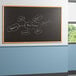 A black Aarco chalkboard with white writing on it.