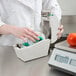 A person in a white coat putting a roll of tape into a Cardinal Detecto thermal label printer.