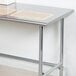 A stainless steel Advance Tabco open base work table.