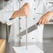 A person using a Victorinox knife sharpening steel to sharpen a knife.