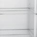 A white Traulsen reach-in refrigerator with metal shelves.