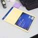 A yellow Ampad writing pad on a desk.