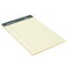A close-up of a TOPS narrow ruled yellow writing tablet with lined paper.