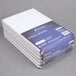 A stack of Ampad Gregg Ruled white wirebound steno pads.