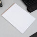 An Ampad wirebound planner pad with a green cover on a desk.