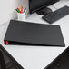 A Cardinal black binder with locking tabs on a desk.