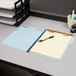 A Pendaflex letter size fastener folder with papers on a table.