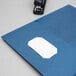 A blue Oxford 2-pocket folder with a white tag on it.